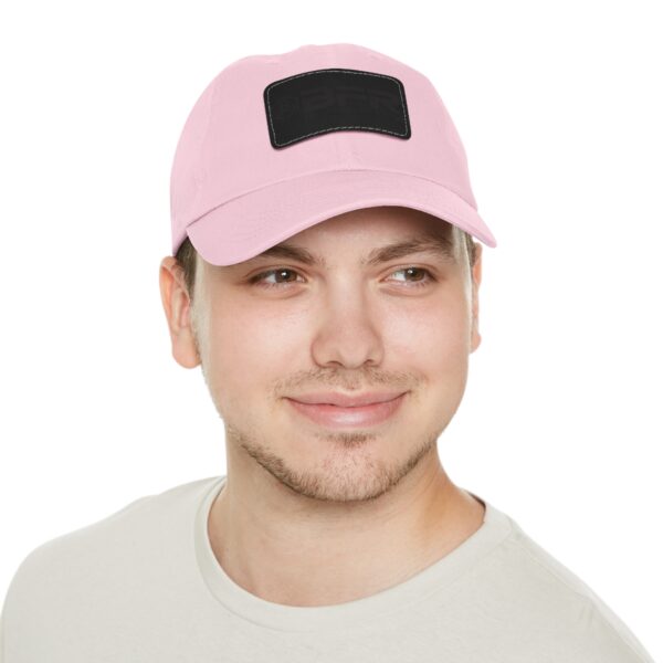 A man wearing a BFR Logo - Dad Hat with Leather Patch (Rectangle) a pink baseball cap with a black patch.