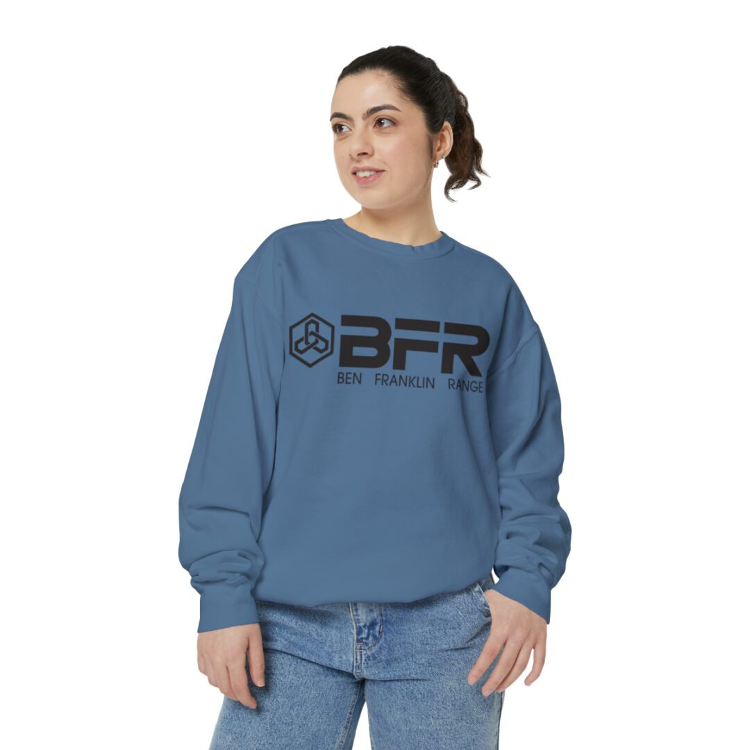 A woman wearing a blue BFR Logo - Unisex Garment-Dyed Sweatshirt with the word bfr on it.