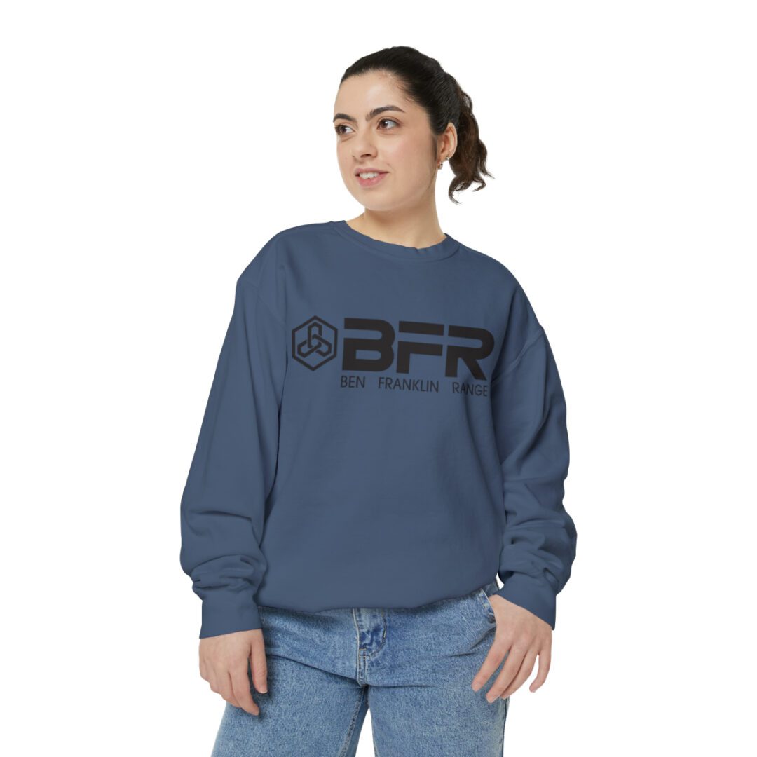 A woman wearing a blue BFR Logo - Unisex Garment-Dyed Sweatshirt with the word gfr on it.