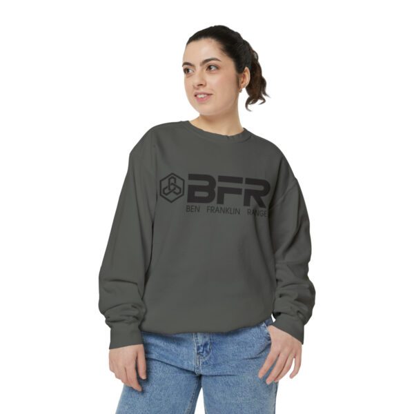 A woman wearing a grey sweatshirt with the BFR Logo - Unisex Garment-Dyed Sweatshirt on it.