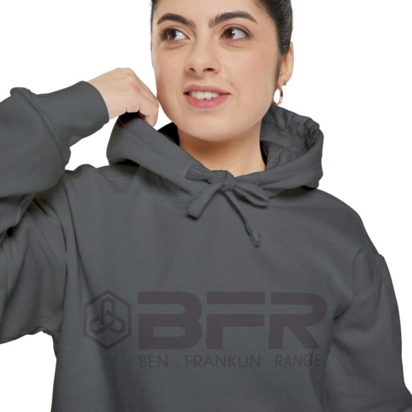A woman wearing a BFR Logo - Unisex Garment-Dyed Hoodie with the word bfr on it.
