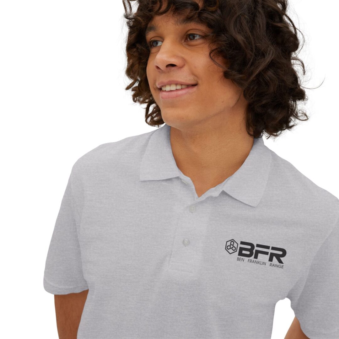 Person smiling in a gray polo shirt.