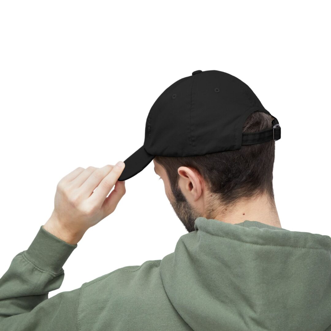 Man adjusting a black baseball cap.