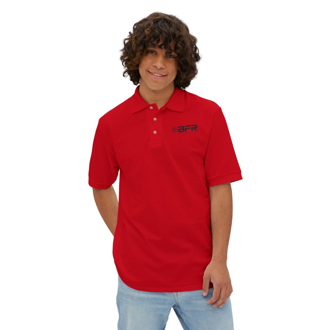 Man in red polo shirt smiling confidently.