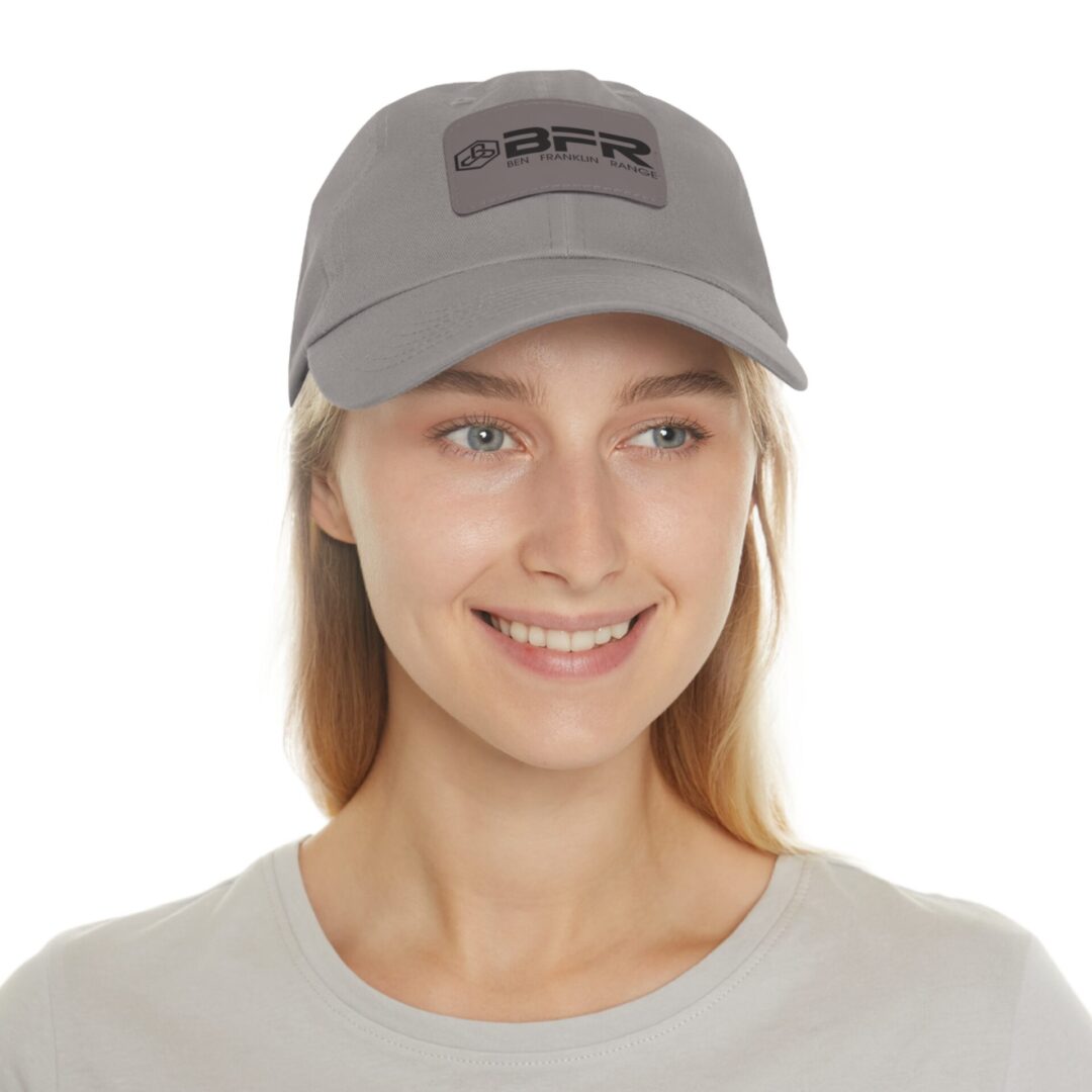 Smiling person wearing a gray baseball cap.