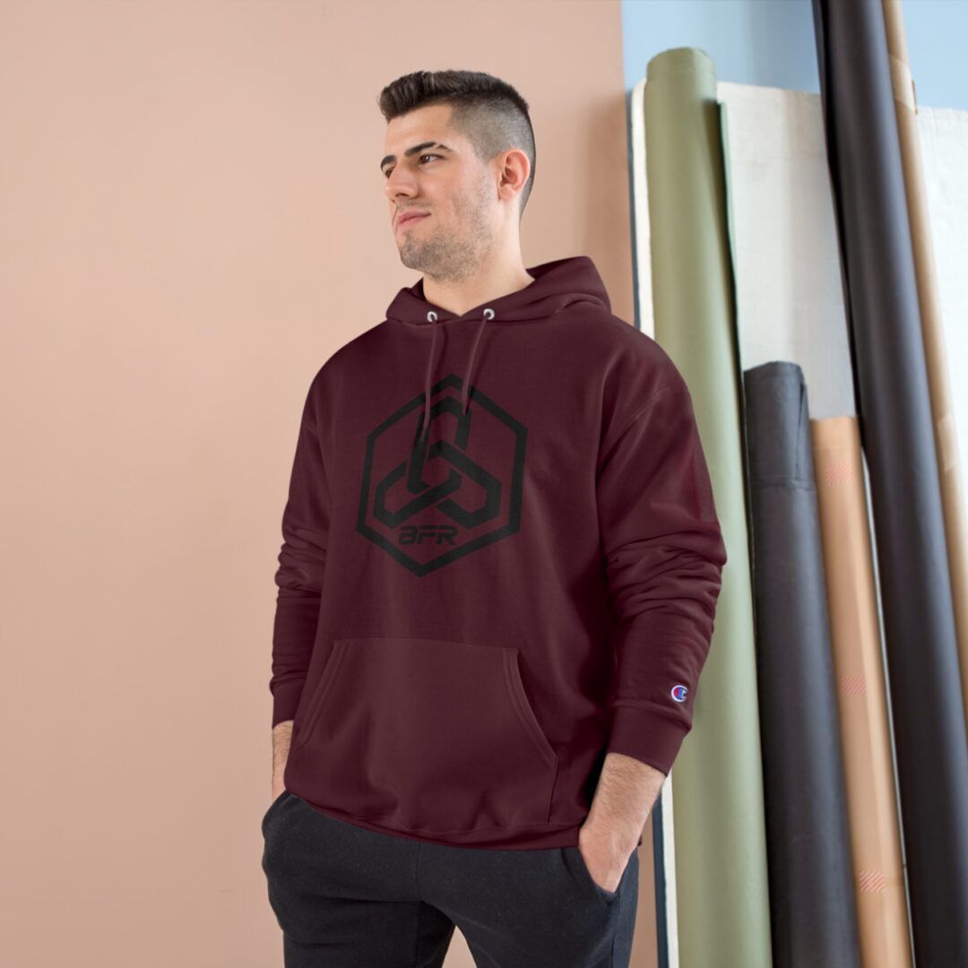 Man wearing maroon hoodie, standing indoors.
