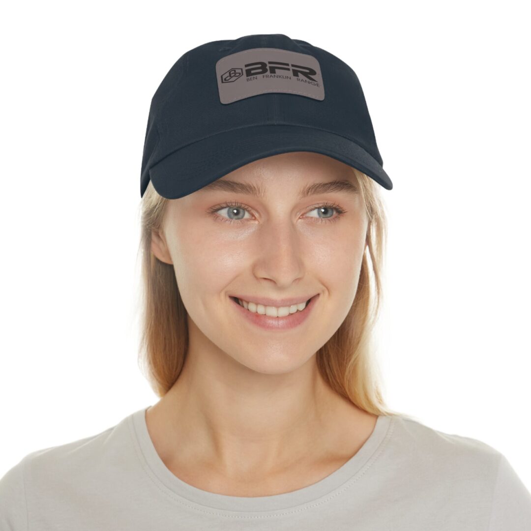 Smiling person wearing a black baseball cap.