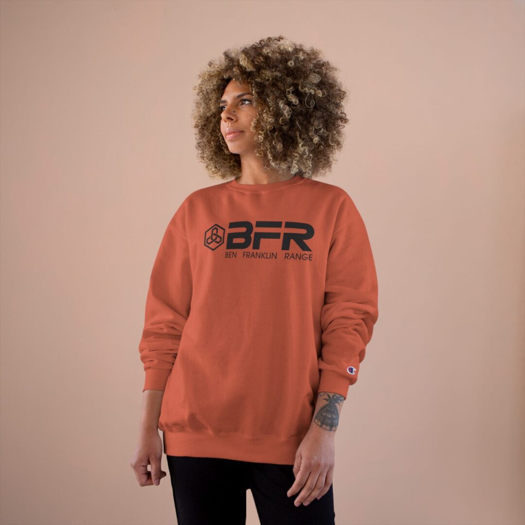 Person wearing orange BFR sweatshirt, neutral background. Person wearing orange BFR sweatshirt, neutral background.