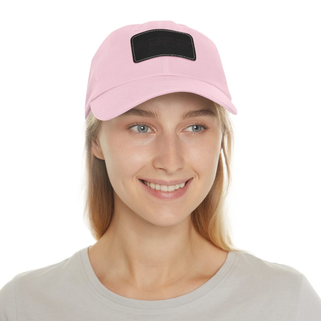 Smiling person wearing a pink baseball cap.