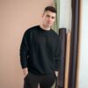 Man in black sweatshirt posing indoors. Man in black sweatshirt posing indoors.