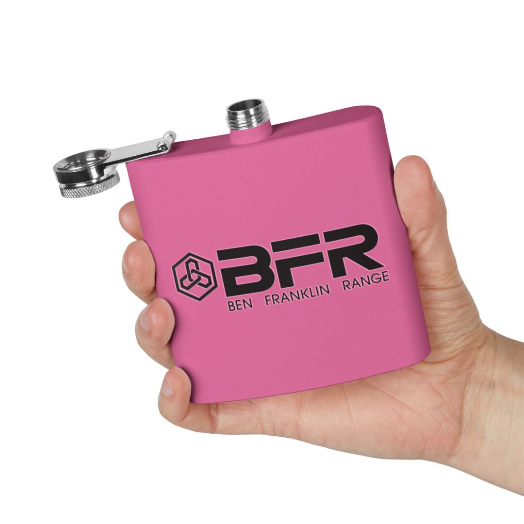 Hand holding pink flask with logo.