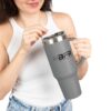 Woman holding large gray travel mug.
