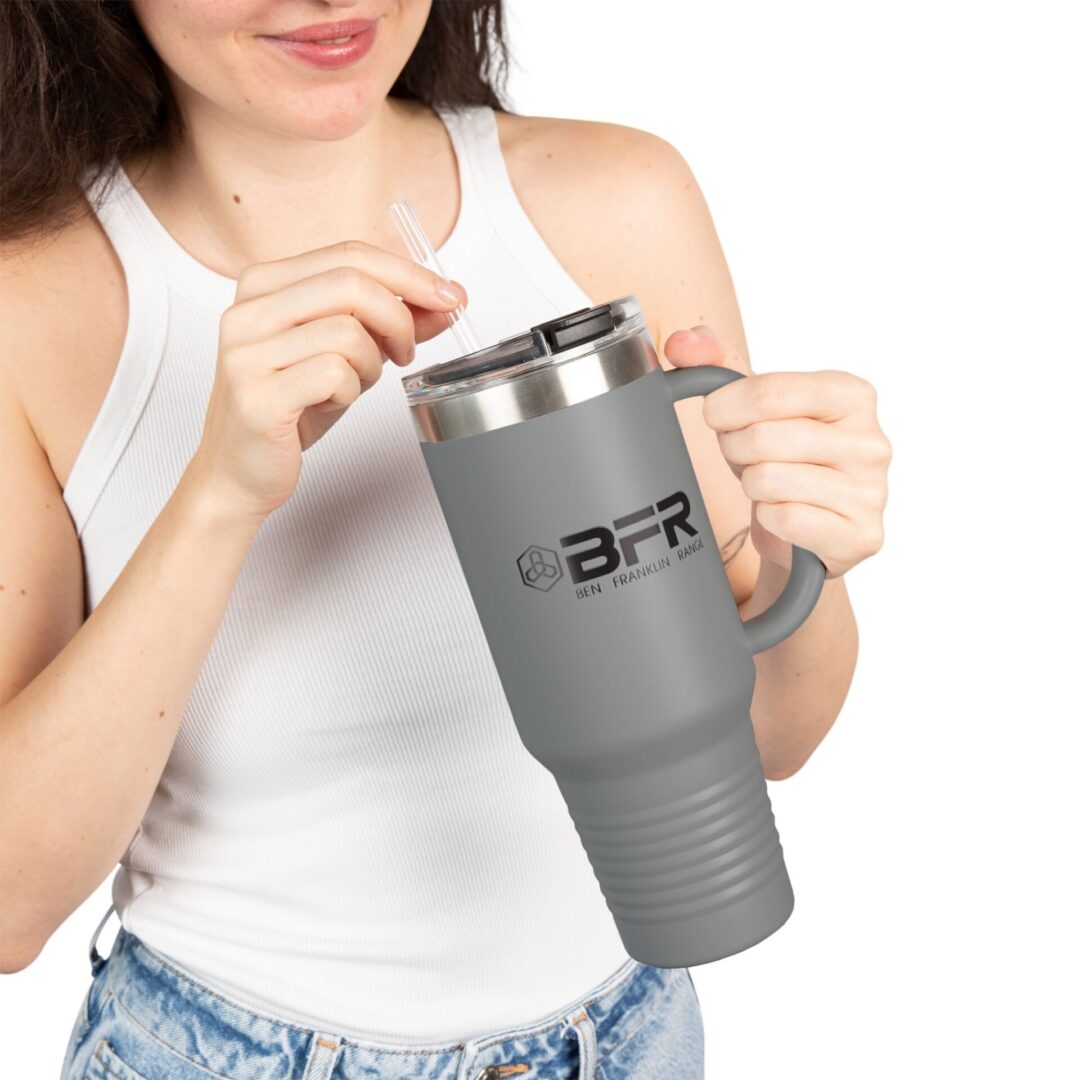 Woman holding large gray travel mug.