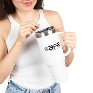 Woman holding large white travel mug.