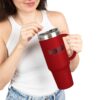 Woman holding red tumbler, sipping drink.