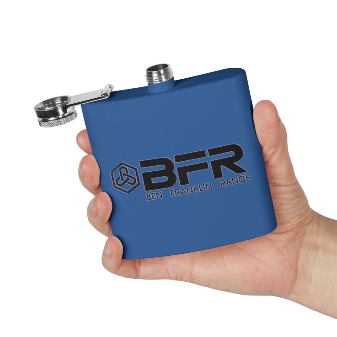 Hand holding blue flask, open cap.
