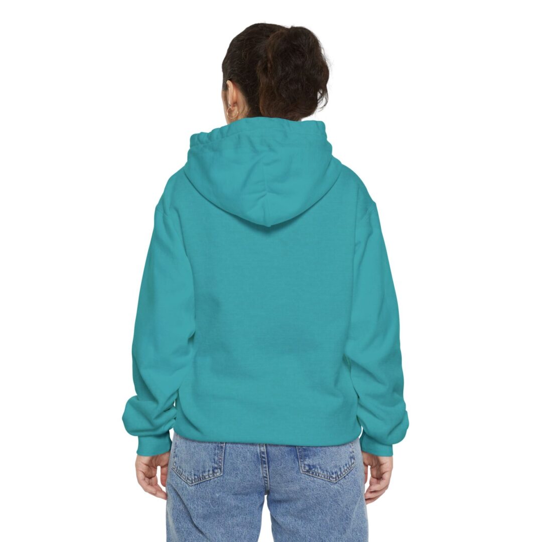 Person in turquoise hoodie and jeans, back view.